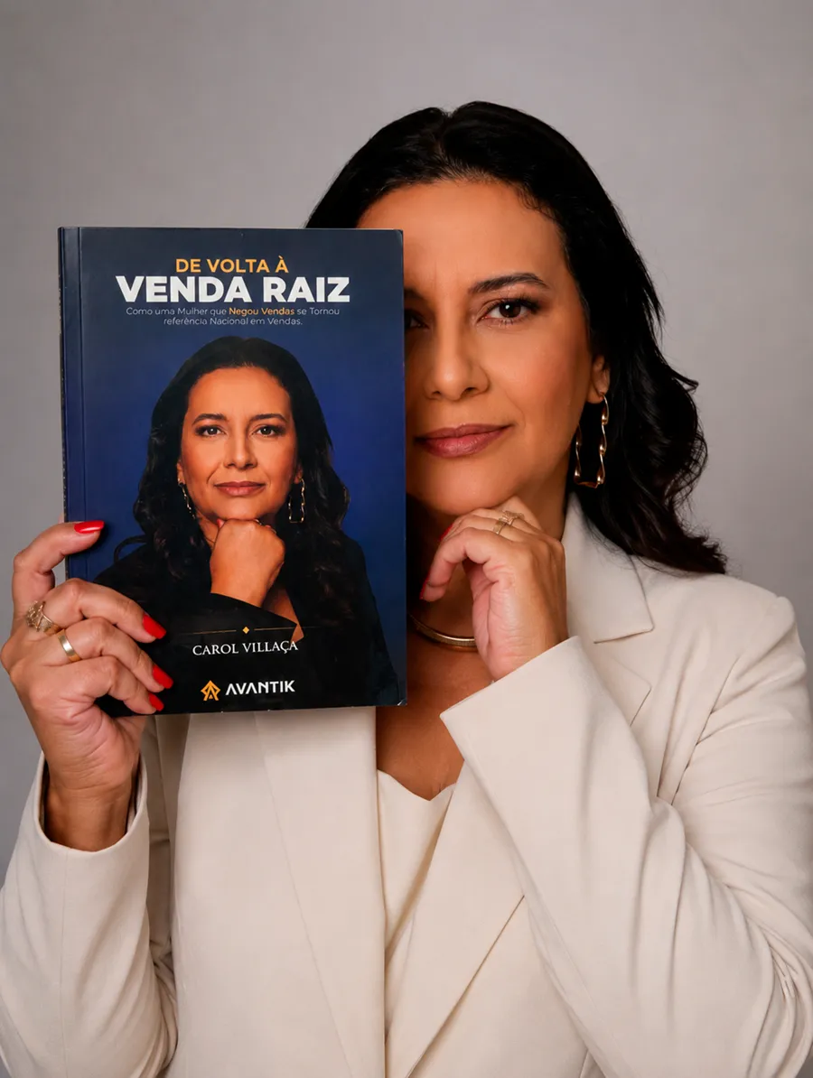 Carol Villaça segurando o livro De Volta à Venda Raiz ao lado do rosto